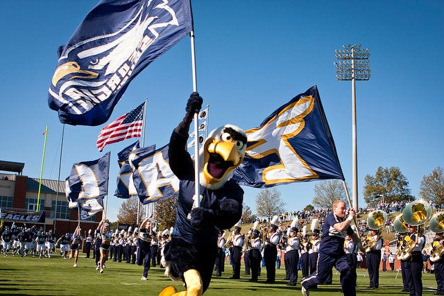 GUS the Eagle running onto the Georgia Southern football field while waving a flag