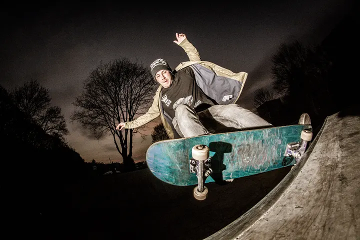 Skateboarder grinding on a ramp at night