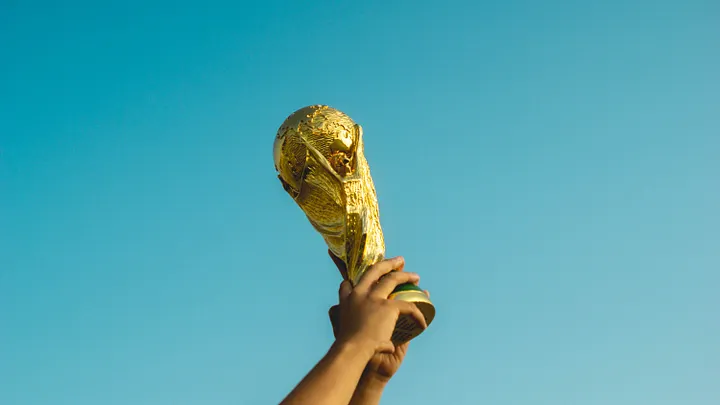 Hand holding a trophy against a blue sky