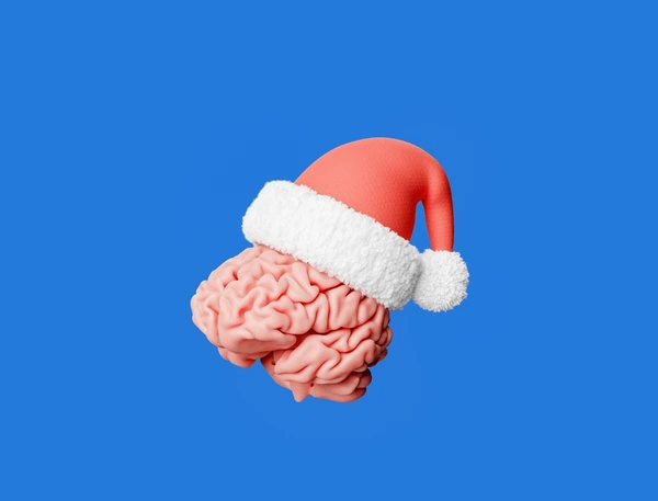 A model of a human brain wearing a red-and-white Santa hat against a blue background