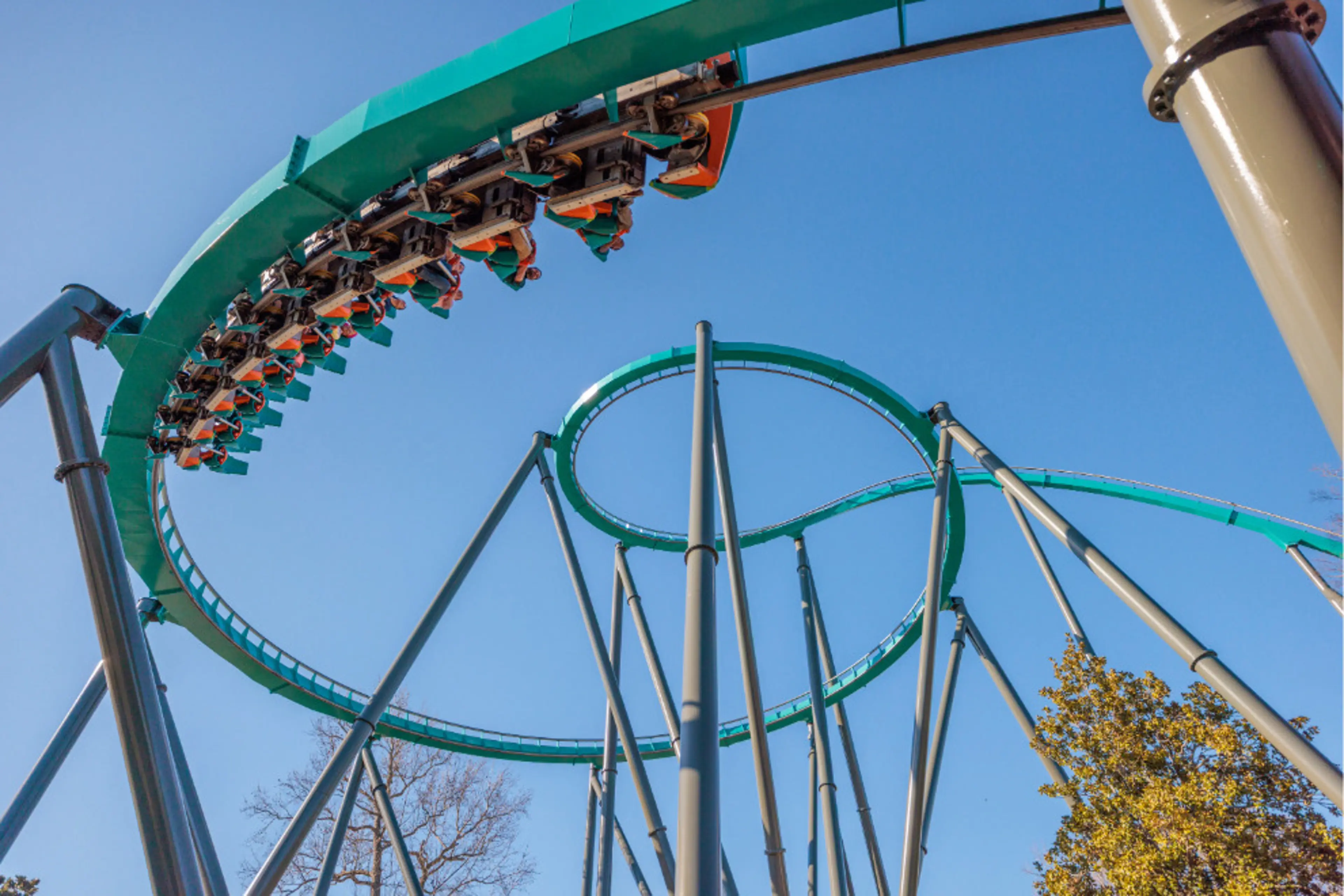 A green train on THE RIDDLER Mindbender traveling upside down through a loop at Six Flags Over Georgia