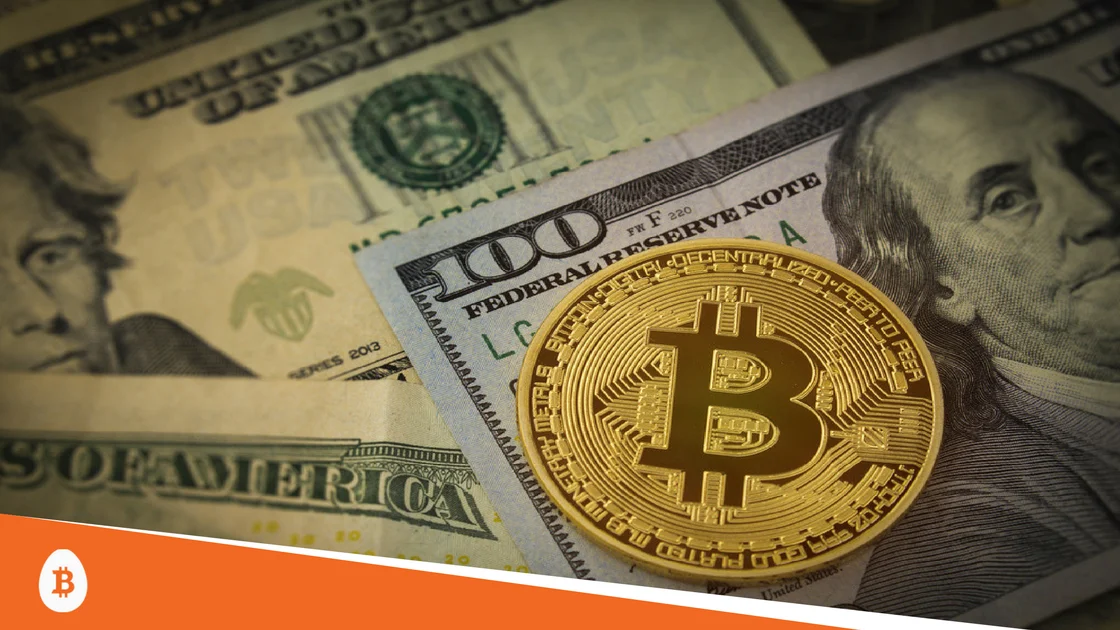 A physical Bitcoin token resting on United States dollar bills