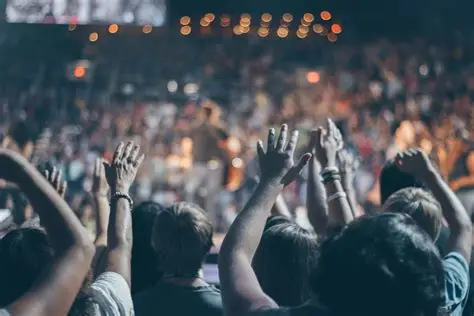 A large crowd raising their hands